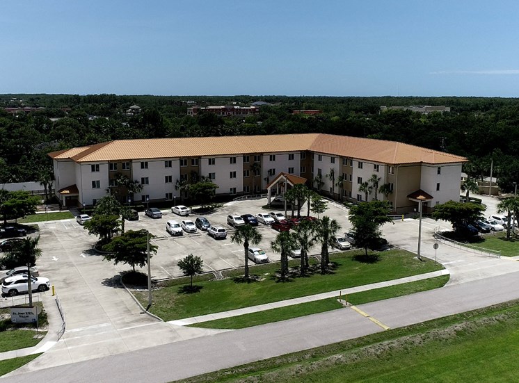 St. John XXIII Villas with large parking lot and palm trees